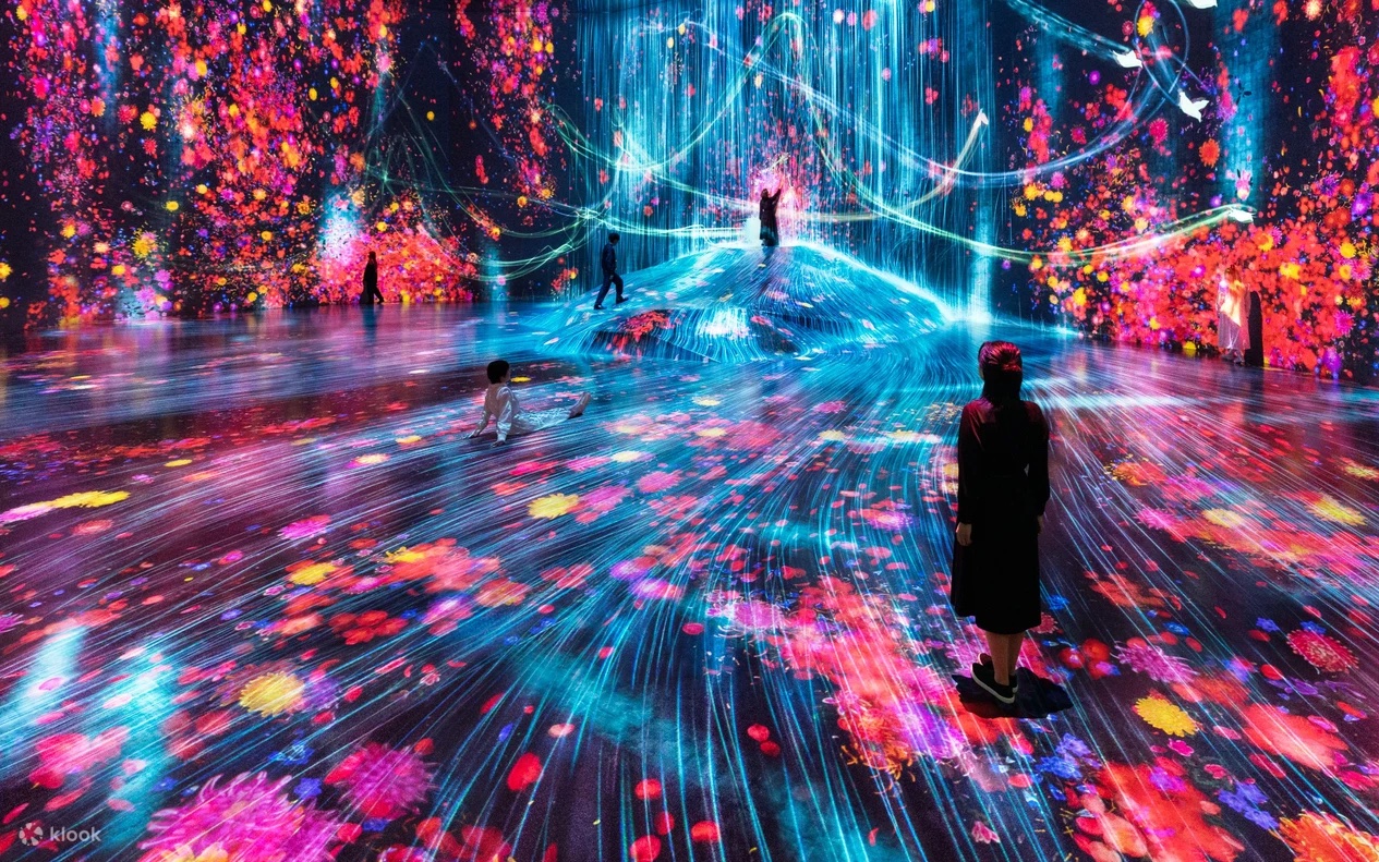 Visitors inside a vivid digital flower installation at teamLab Borderless